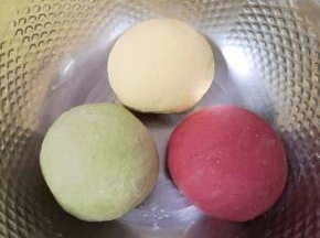 将三种颜色的面团放入盆里，盖上保鲜膜饧半个小时。