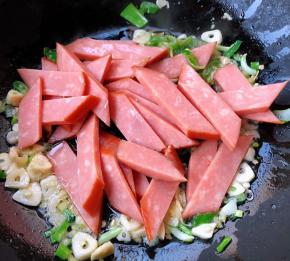 放入火腿片大火快速翻炒