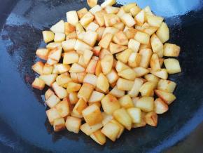 另起锅放少许油，放土豆丁煎至表面焦黄盛出。