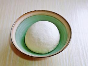首先将面团发酵上哈，面粉中加入酵母粉，分次倒入温水，搅拌絮状，再揉成面团，盖上盖子进行发酵。