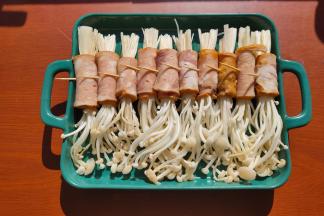 把准备好的培根卷码放整齐，烤箱上下火180度预热。