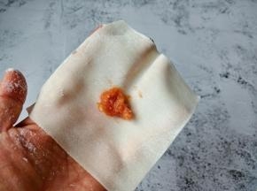 馄饨皮放三角形状，筷子在皮子中间放一点肉馅。