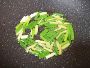 炒锅内倒适量的食用油烧热，下入葱段炒香。
