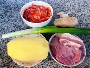 准备原材料五花肉、辣白菜切成小段、土豆去皮洗净、葱、姜、蒜
