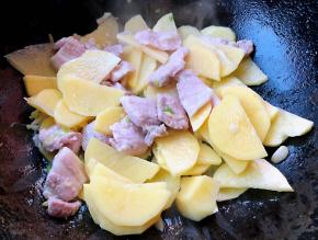 五花肉炒至变色放入土豆片翻炒均匀