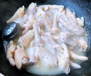 锅中倒入清水放入凤爪、调味盒、料酒大火煮至凤爪熟透而不软烂即可