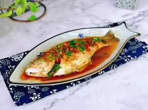 取出鱼盘，淋上热油，撒上葱花。(锅中加入食用油烧热淋在鱼身上)