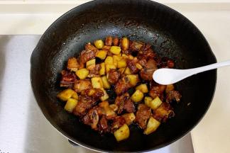 汁收到1/3时位置时，倒入煎过的土豆炒匀，小火焖煮3分钟，汁收完之后加盐拌匀。