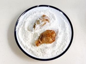 淀粉和面粉混合均匀，腌制好的鸡腿裹上干粉。