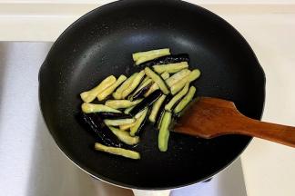 锅中倒入少许食用油，加入茄子翻炒片刻。