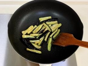 锅中倒入少许食用油，加入茄子翻炒片刻。
