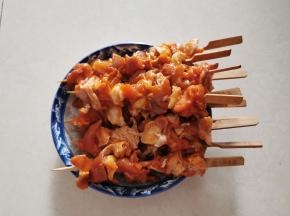 将腌好的材料，用竹签把鸡肉和掌中宝隔开逐个串起