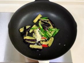 加入蒜蓉、小米辣和线椒翻炒。