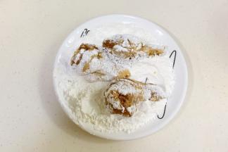 淀粉和面粉混合拌匀，鸡腿裹上粉类。