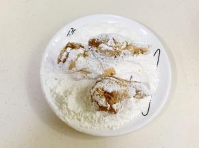 淀粉和面粉混合拌匀，鸡腿裹上粉类。