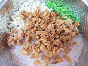 切好的豆角、豆腐和粉条一起放进盆里，加入猪油渣搅拌均匀。