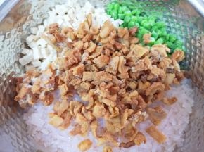 切好的豆角、豆腐和粉条一起放进盆里，加入猪油渣搅拌均匀。