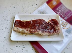 用厨房纸吸干表面水分，撒上黑胡椒碎、海盐、香草碎腌制入味。
