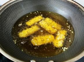 锅内放宽油，烧至五成热时下入牛肉棒小火炸制。