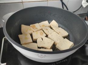起锅热油，豆腐下锅码平，中小火慢慢煎炸。
