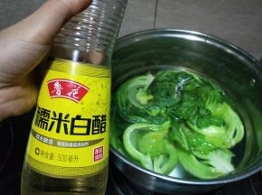 最好选用不锈钢锅。加入适量的水，水能没过菜即可，加入盐，最好尝一下，跟我们平时炒菜的咸度就可以了。放入芥菜，大约煮一分钟后关火，给菜断生不能煮太久会煮熟。现在的天气有点凉，加点米醋有助于发酵，这个没有固定分量，喜欢酸一点就多放一点。