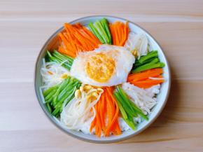 大碗放一碗米饭，码上炒好的配菜与牛肉丝。