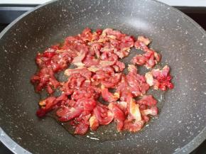 热锅热油下辣椒段与牛肉丝翻炒。