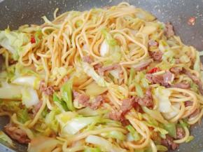 用两双筷子快速地将面条翻炒均匀就可以吃了。