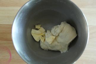 厨师机开一档，将材料混合成团。然后转2-3档打到略光滑，能扯出粗膜的状态。然后加入盐和软化好的黄油。