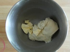 厨师机开一档，将材料混合成团。然后转2-3档打到略光滑，能扯出粗膜的状态。然后加入盐和软化好的黄油。