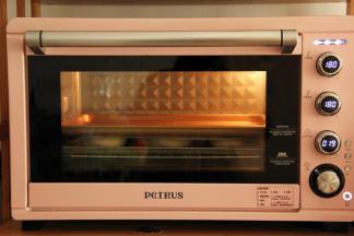 在发酵好的面团上盖上一张油纸，然后压上一个底部平的烤盘，扁扁的小圆饼面包就是这么来的（压在上方的烤盘不要卡在烤箱上，不然面包烤的时候没有空间膨胀的）。然后放入烤箱中下层，转上下180度，烤20分钟。