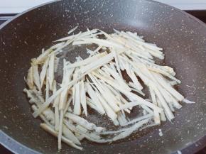 热锅热油下笋丝爆炒至微黄。