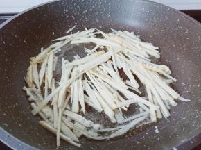 热锅热油下笋丝爆炒至微黄。