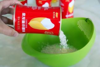 小鲜米倒入淘米盆，洗净之后放入电饭锅，加入适量的水，按“煮沸”键。