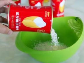 小鲜米倒入淘米盆，洗净之后放入电饭锅，加入适量的水，按“煮沸”键。