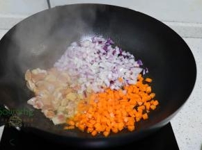 锅里烧热之后，倒入鸡腿肉煸炒六成熟，放入胡萝卜、洋葱炒香。