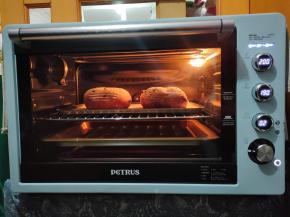 预热十分钟后，把面包胚放入烤箱烘烤25-30分钟即可。