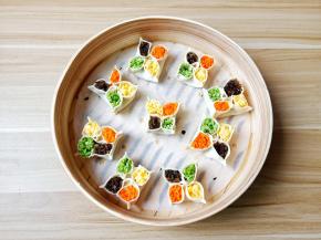 再将饺子两边往中间捏，相邻的两边再捏起来，放上配菜就可以。