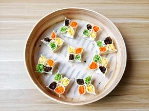 再将饺子两边往中间捏，相邻的两边再捏起来，放上配菜就可以。