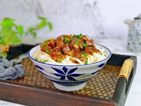 过水的面条捞出淋干水分，放入面碗中，淋上牛排丁酱，撒上葱花就可以啦！