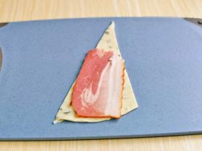 取一块手抓饼，再放上半片培根。