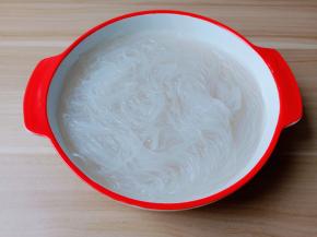 浸泡好的粉丝用剪刀剪成两段。