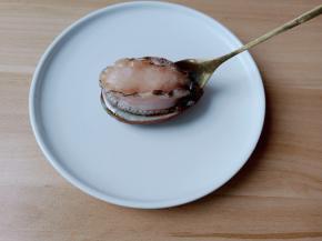 用勺子贴着小鲍鱼的壳。