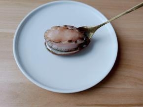 用勺子贴着小鲍鱼的壳。