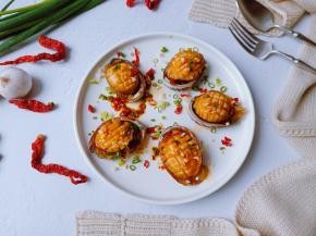 蒸好的鲍鱼加一勺生抽、蒜泥、葱花、辣椒碎淋上热油。