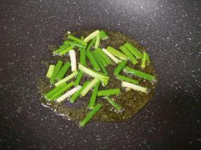 炒锅内继续倒油烧热，下入小葱炒香。