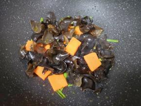 下入黑木耳和胡萝卜翻炒均匀。