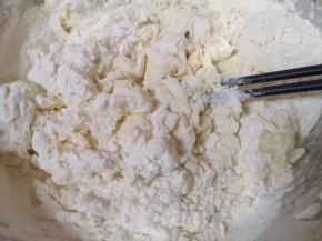 将酵母水加入面粉中，先用筷子搅拌成絮状。