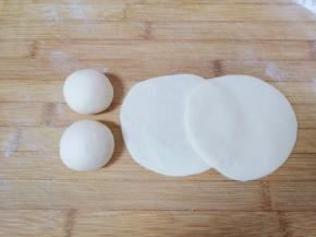 将分好的小剂子揉光滚圆压扁，擀成中间稍厚边缘薄的包子皮。