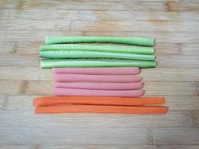 黄瓜和胡萝卜洗干净，火腿肠去掉外包装，分别切成条状，胡萝卜用开水烫一下。